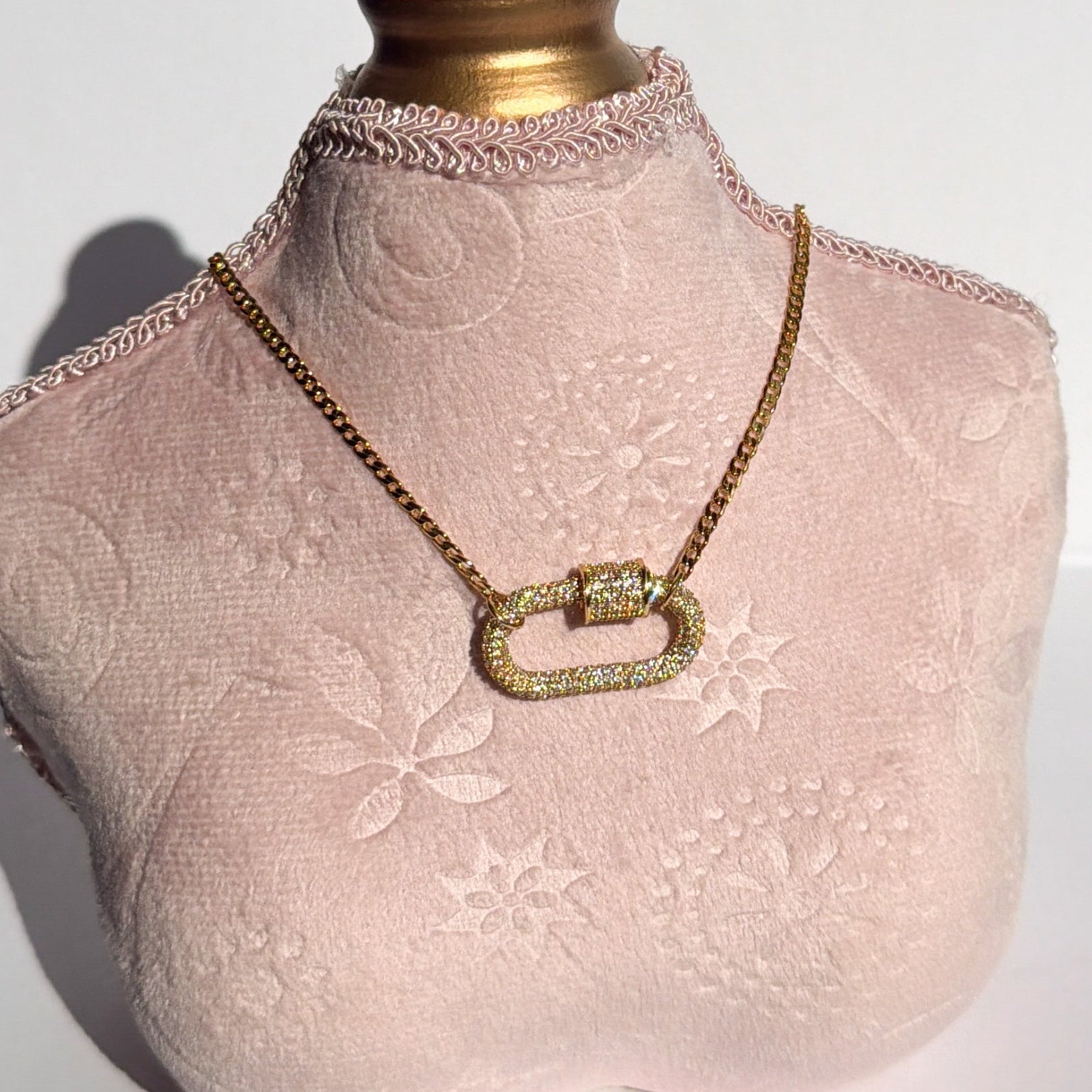 Mannequin bust with lace detail wearing a gold necklace on a white background