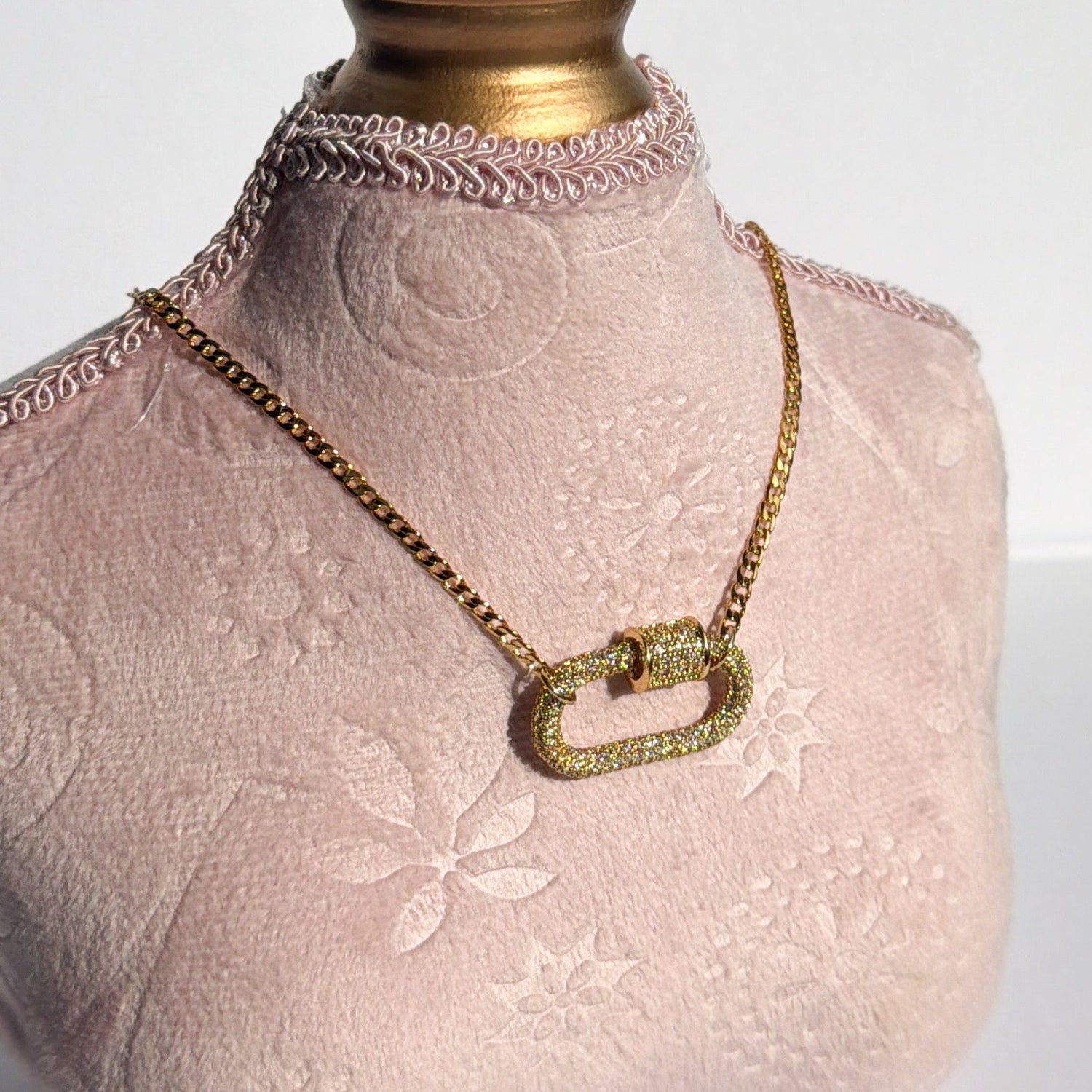 Necklace on a mannequin bust with a gold clasp against a white background
