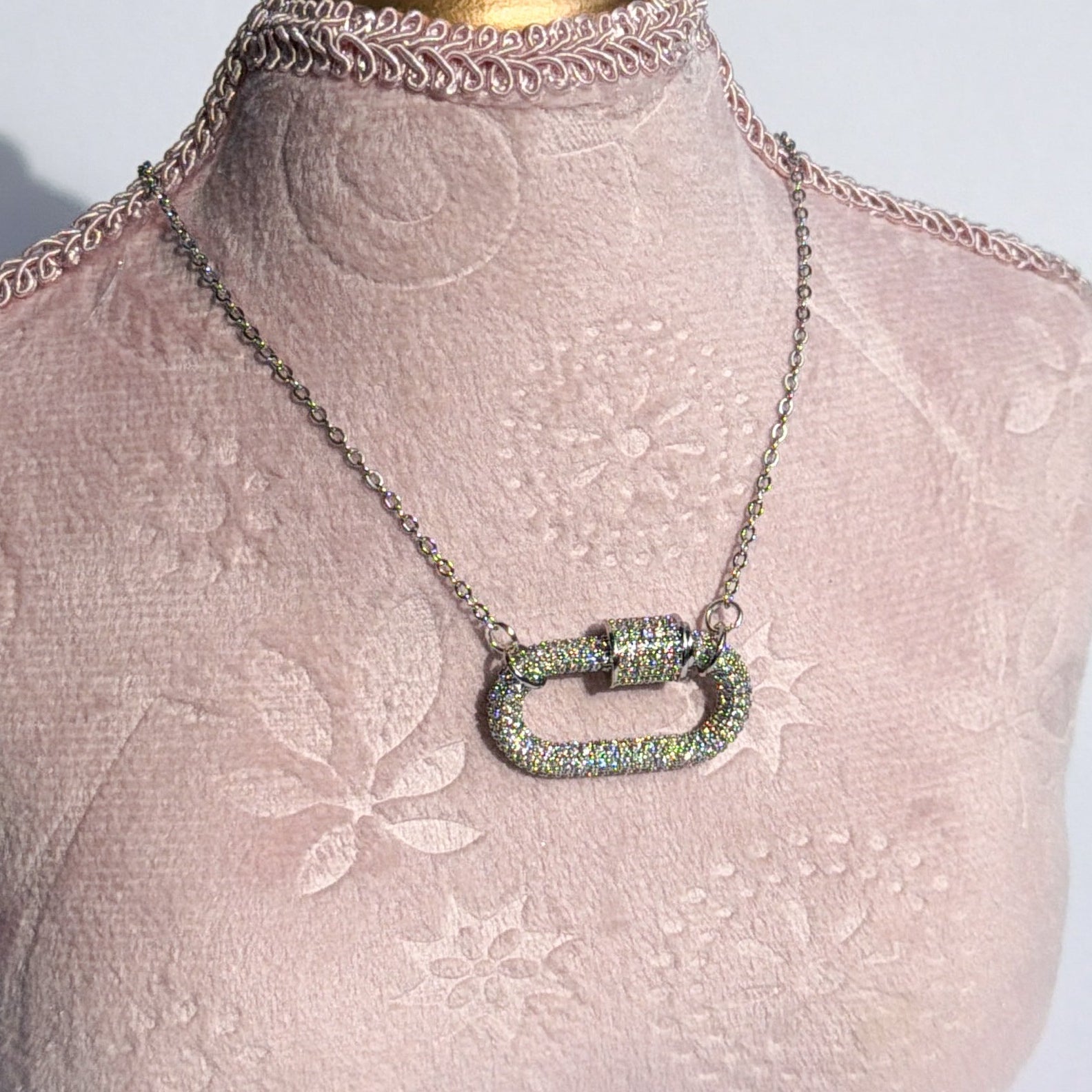 Necklace on a mannequin bust with a decorative headpiece against a white background
