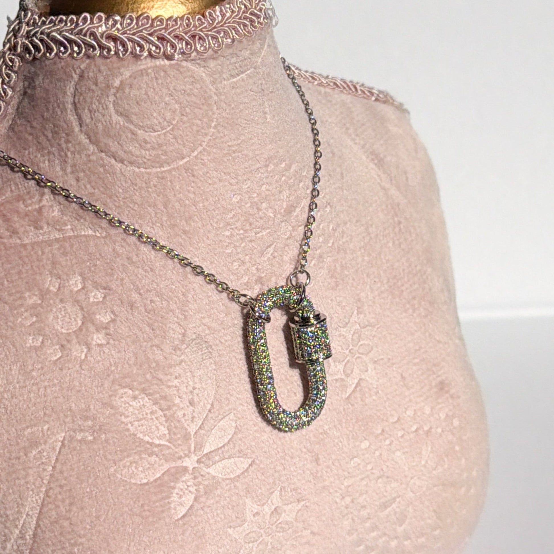 Necklace with a silver pendant on a mannequin wearing a lace dress.