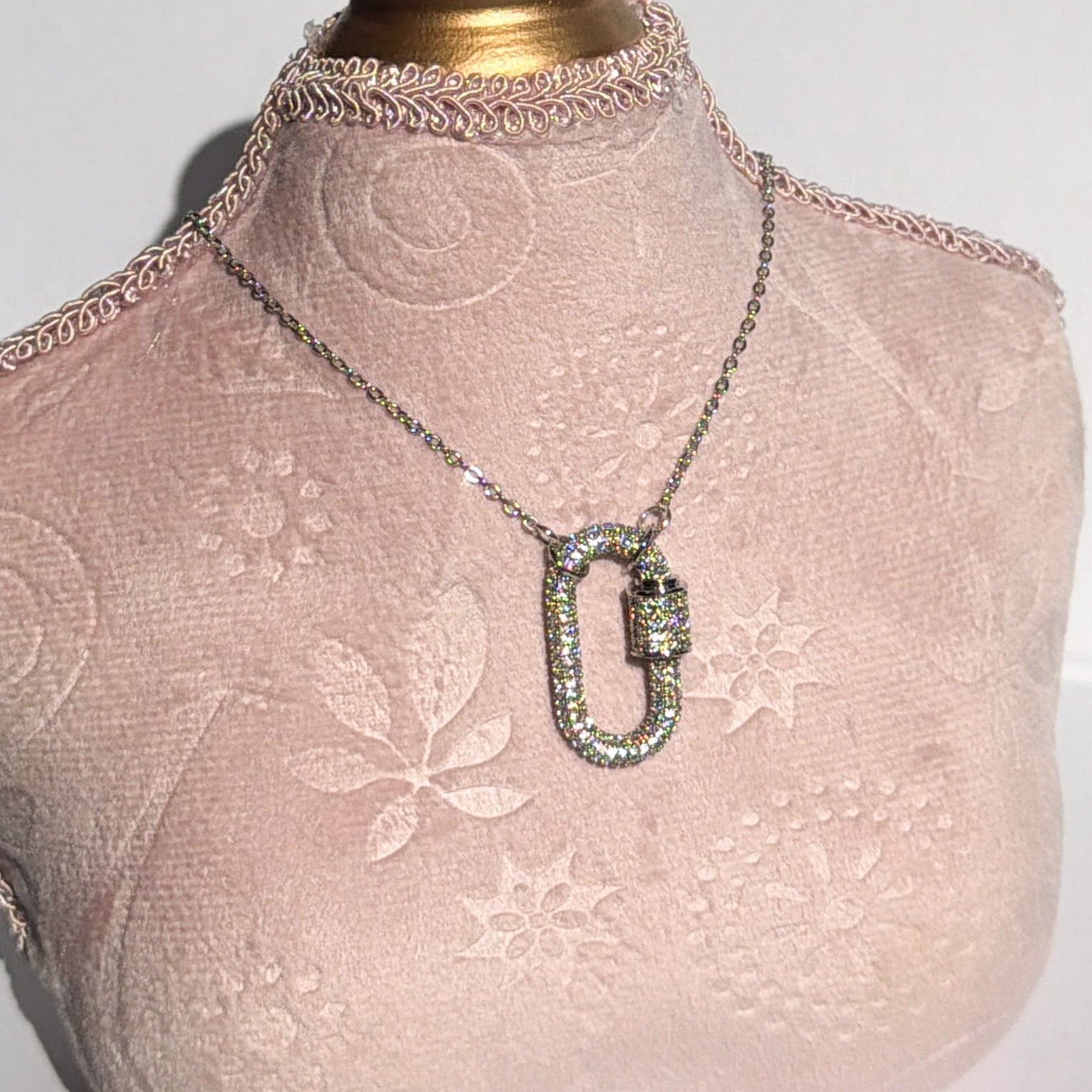 Mannequin bust with pink lace garment and necklace on a white background